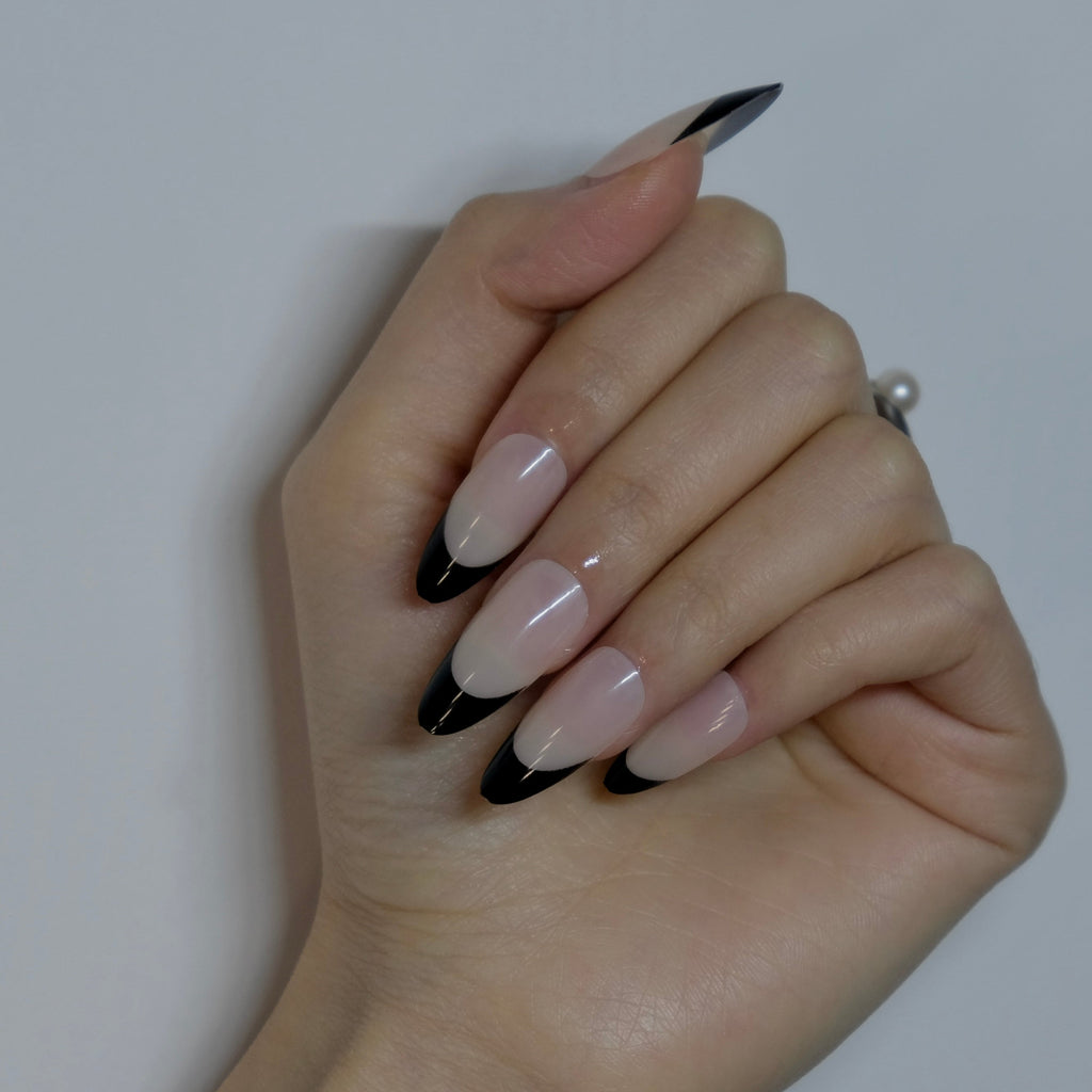 Hand with black and white nail design on a plain background