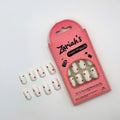 Zariah's press-on nails kit with pink packaging and white nail samples on a light gray background